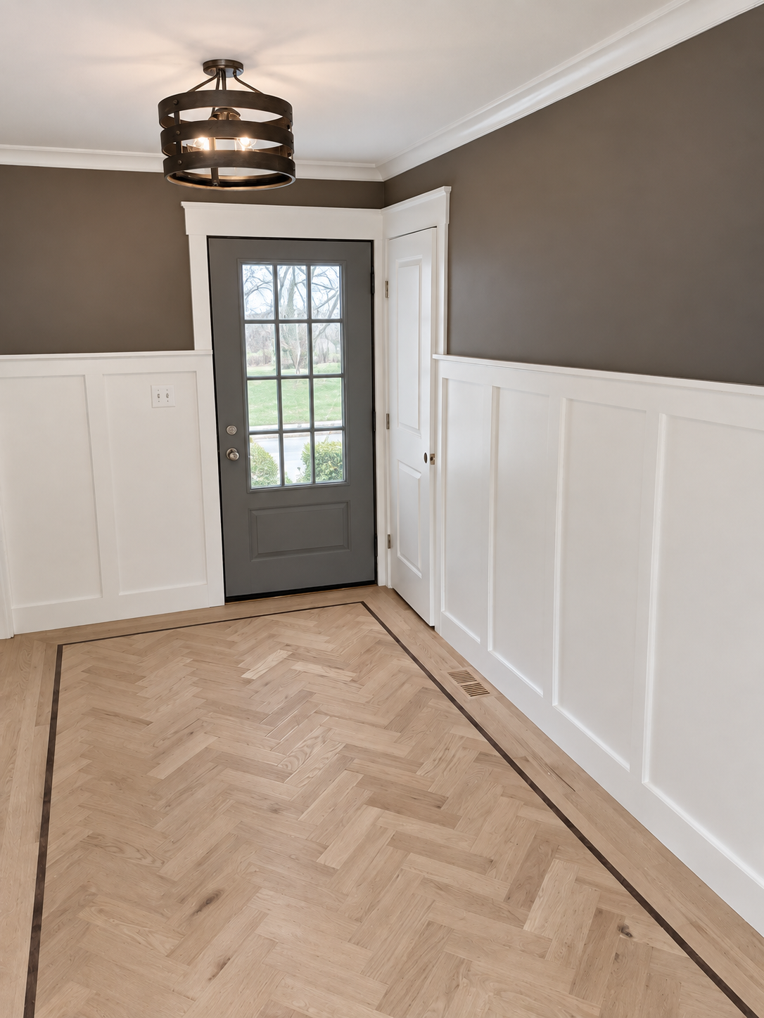 White wainscoting and wood handrail along a finished stair hall